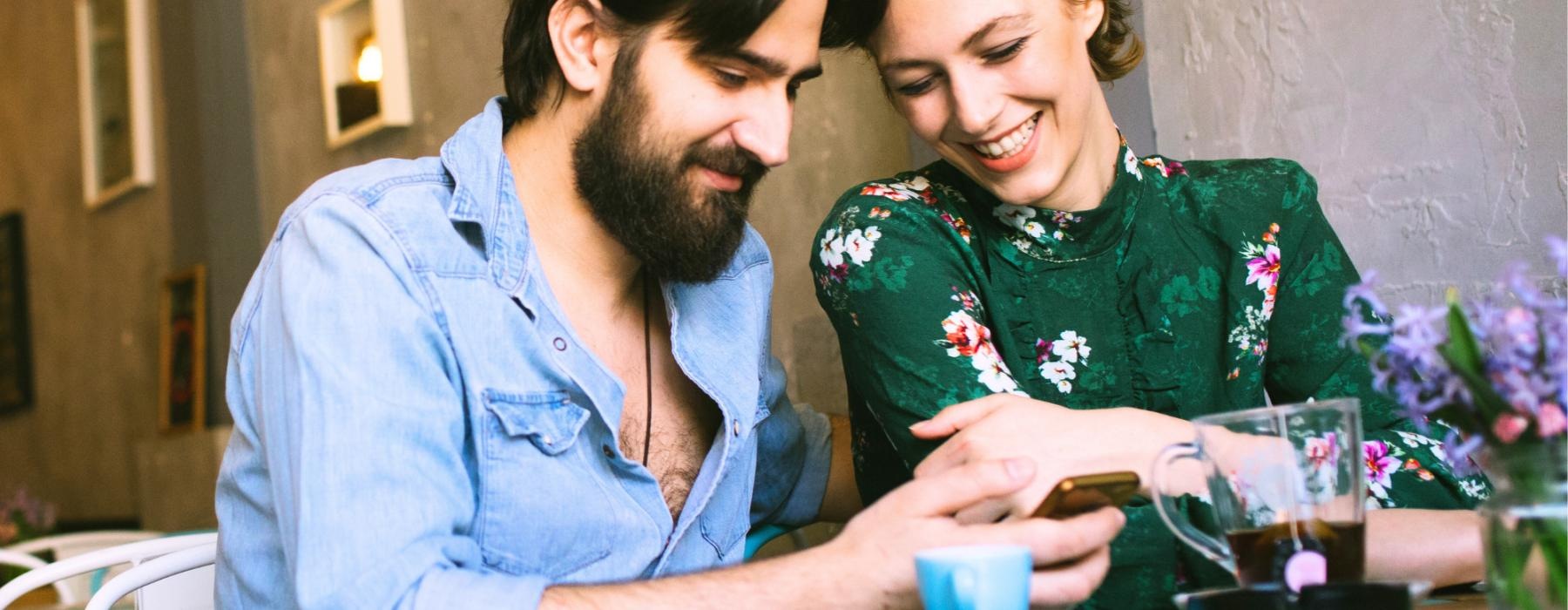 a man and a woman looking at a phone