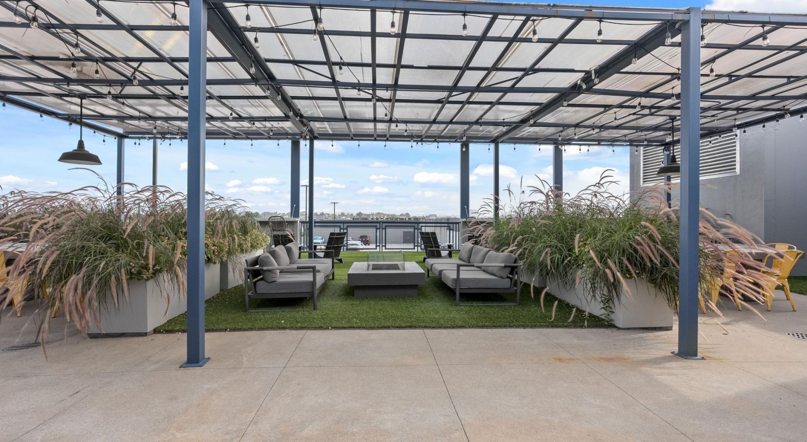 Settle into comfort at The Cleo a covered patio with benches and plants
