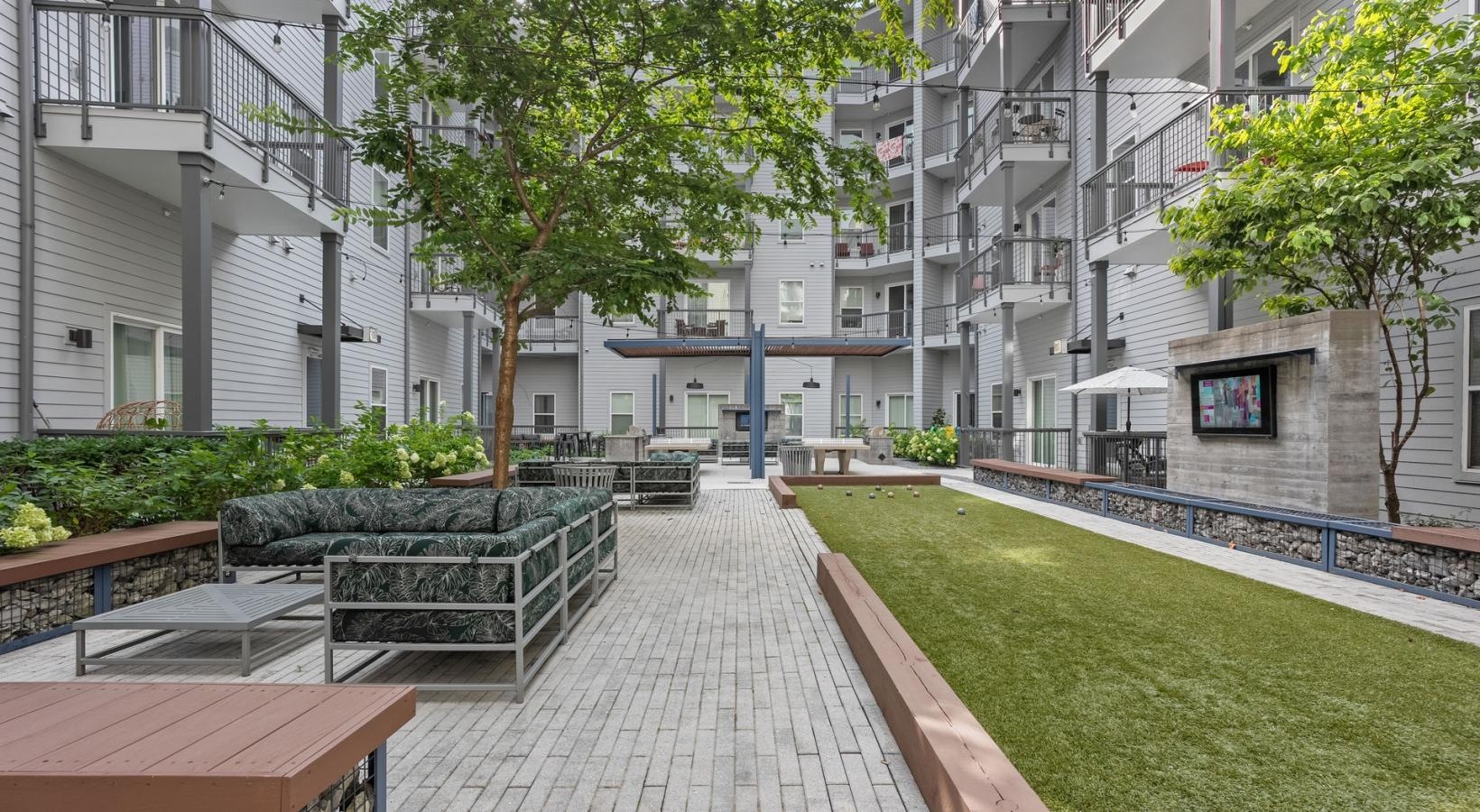 Find your perfect fit at The Cleo a courtyard with benches and trees
